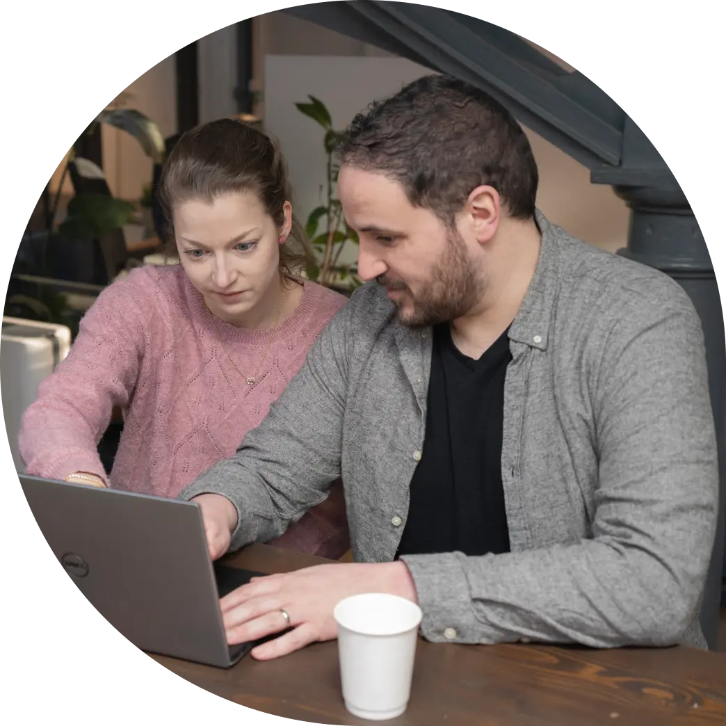 Two Fire team members looking at a laptop and discussing a project.