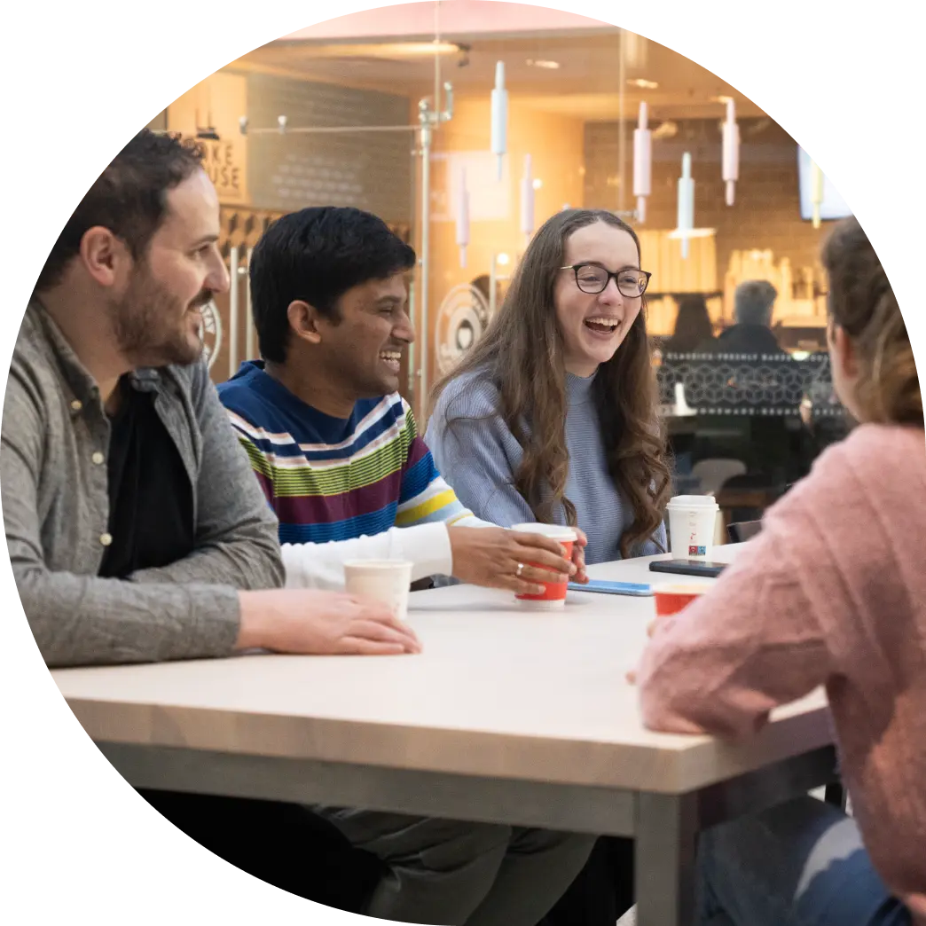Members of the Fire team gathered around a table in a café, engaged in a lively conversation.